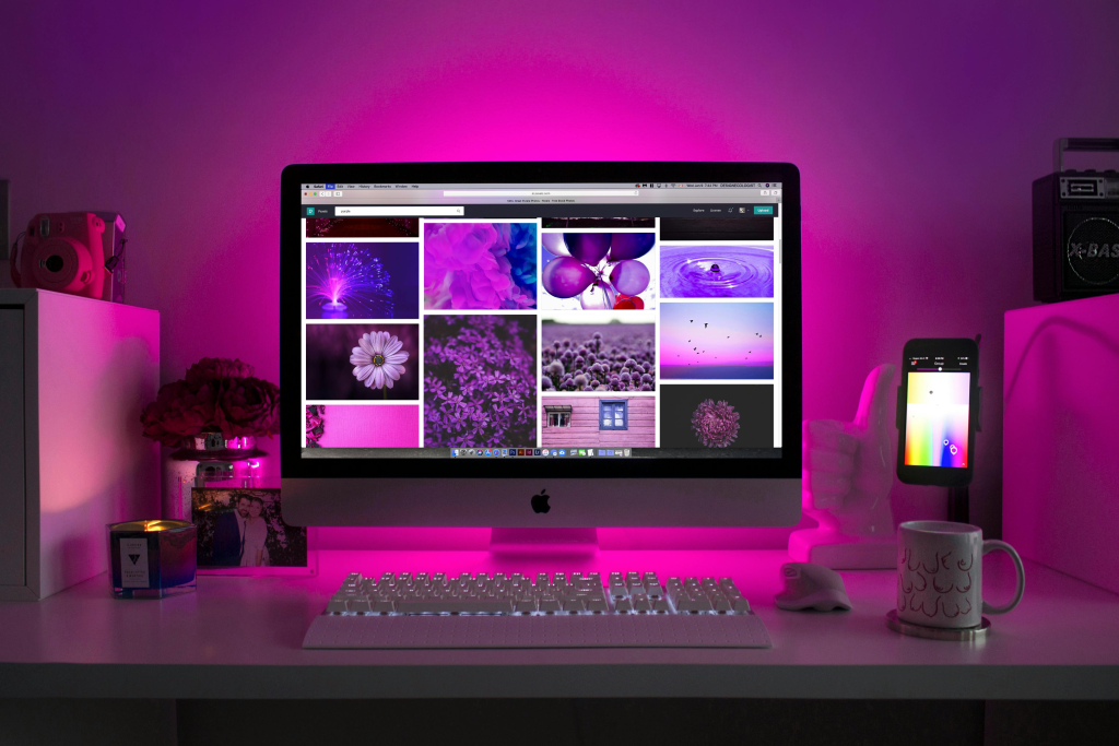 mrs made digital portfolio workspace — iMac with vibrant purple-themed design projects, pink backlighting, and creative desk setup for web design and branding work